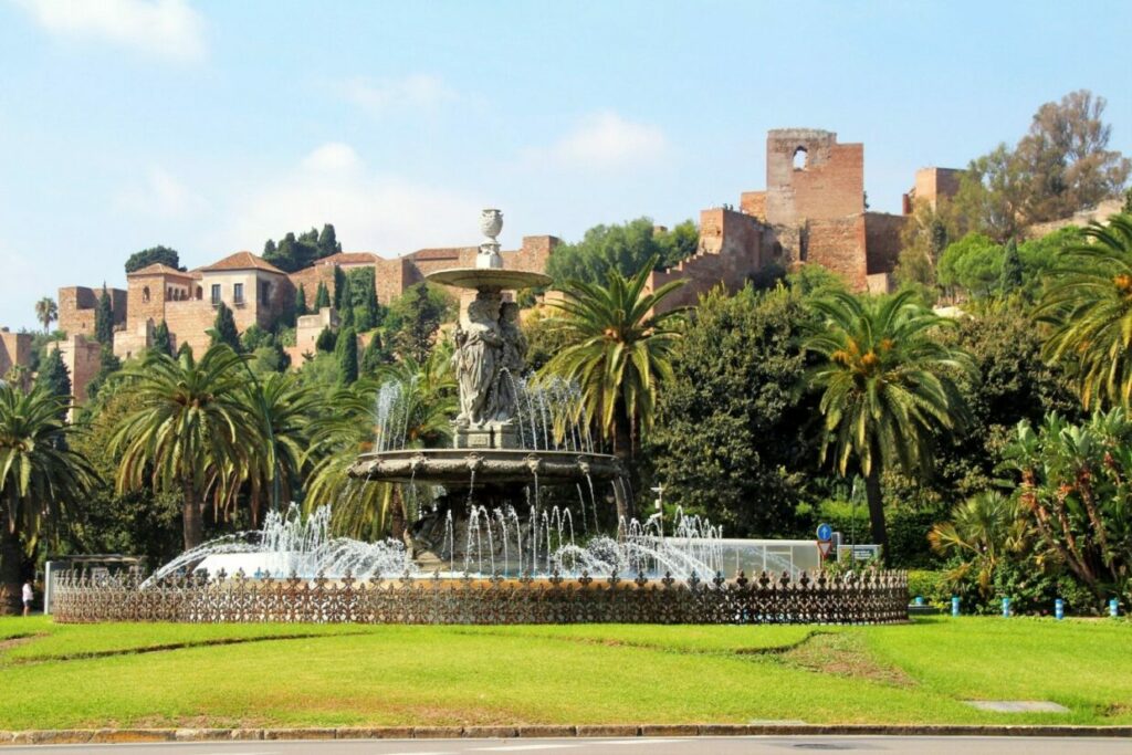 A fountain infront of the Alcazaba of Malaga surrounded by palm trees