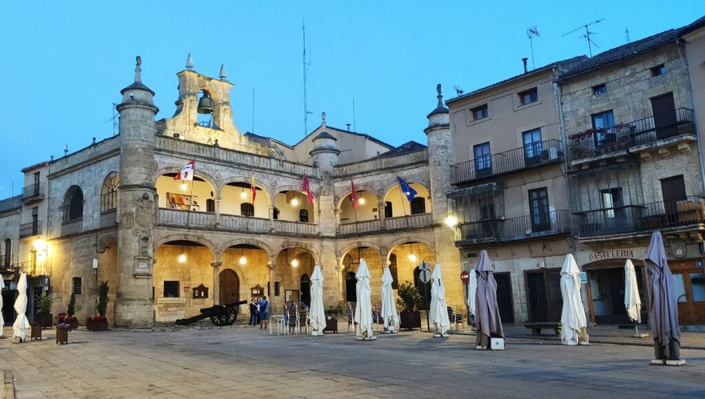 The Ayuntamiento de Ciudad Rodrigo lit up by lights on as night starts to fall in the town