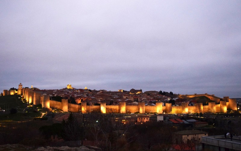 The iconic walls of Avila lit up in the evening as night starts to fall