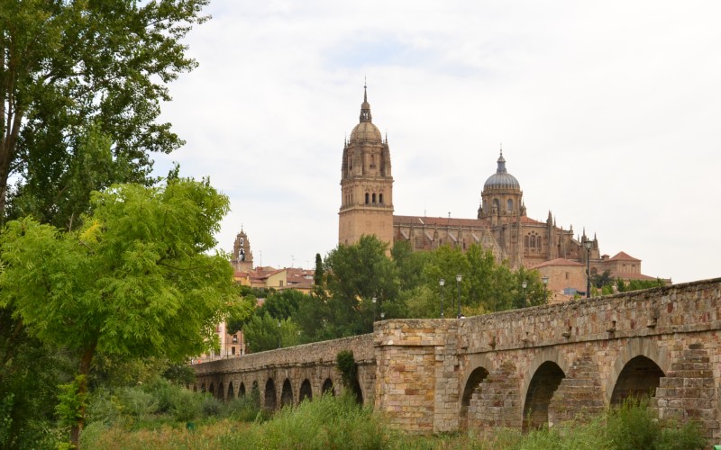 The Roman Bridge crossing the river Tormes in Salamanca with the salamanca Cathedral in the background.